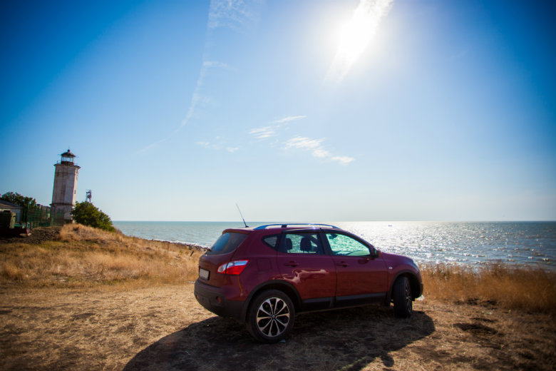 Car Parked Near Coast With Lighthouse