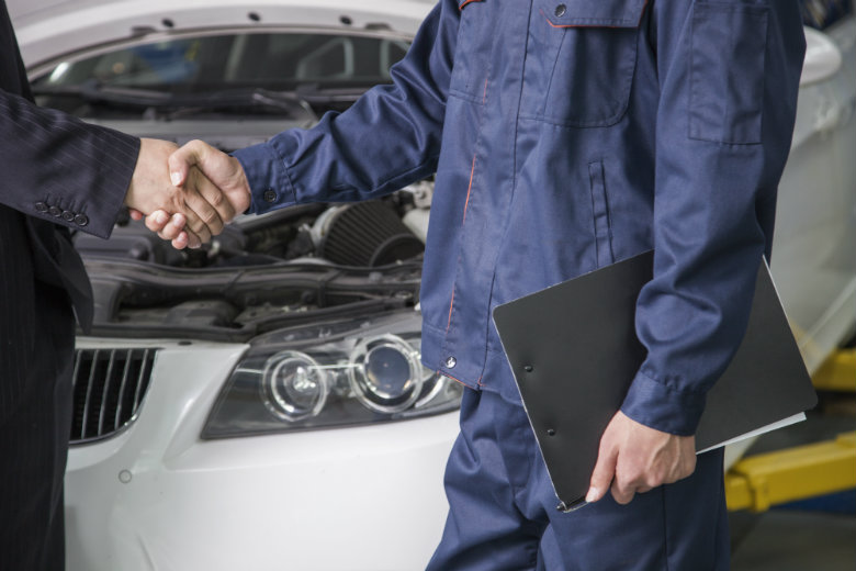 Business man and mechanic shaking hands