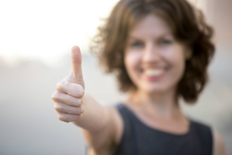 business woman with thumbs up, focus on hand 