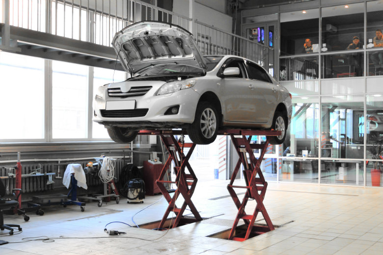 Car on elevator in auto shop