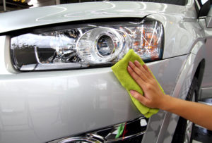 Hand wiping car with polish